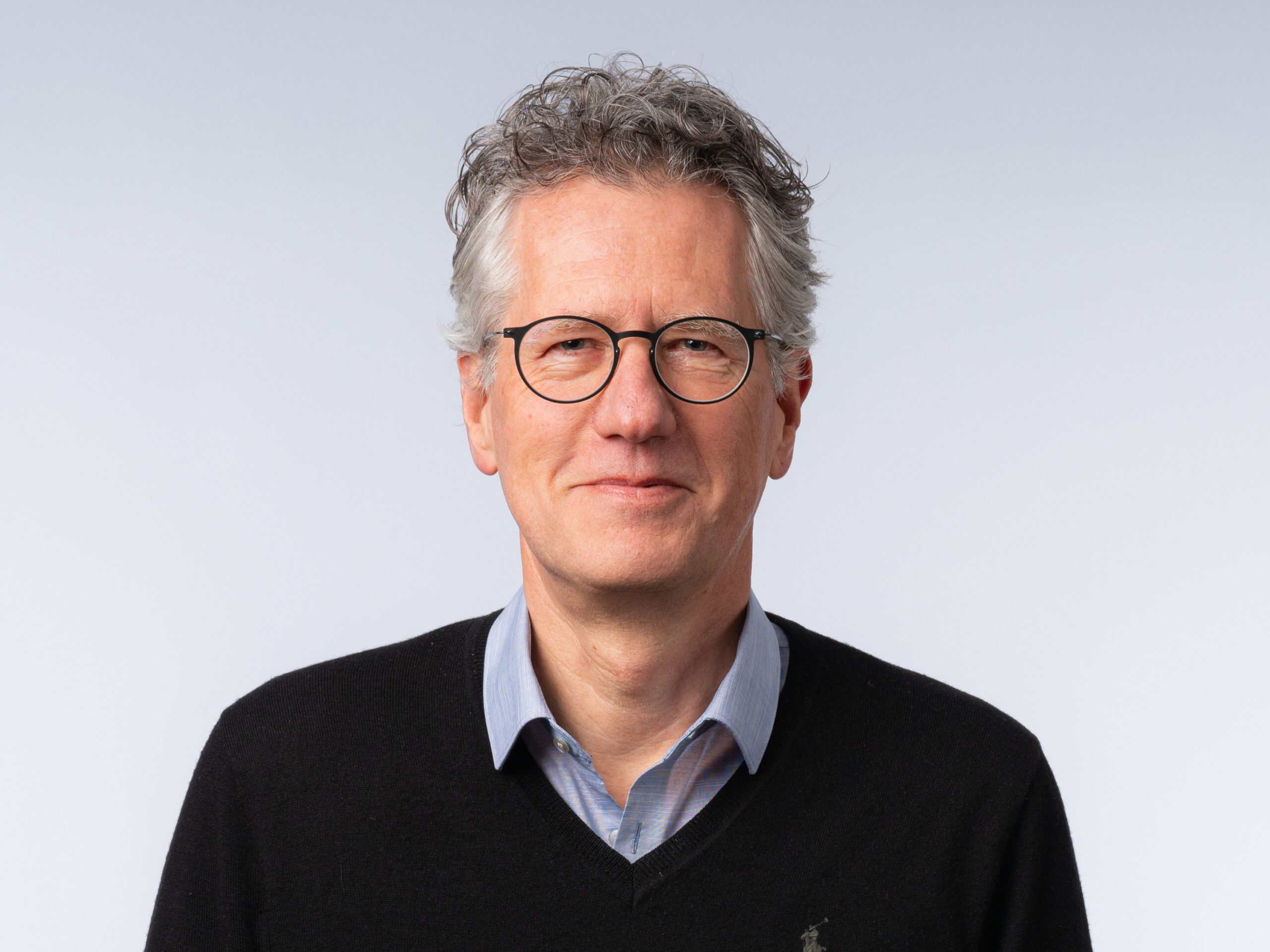 http://Portrait%20of%20Gerhard%20Wanner%20wearing%20round%20glasses%20and%20a%20black%20V-neck%20sweater.